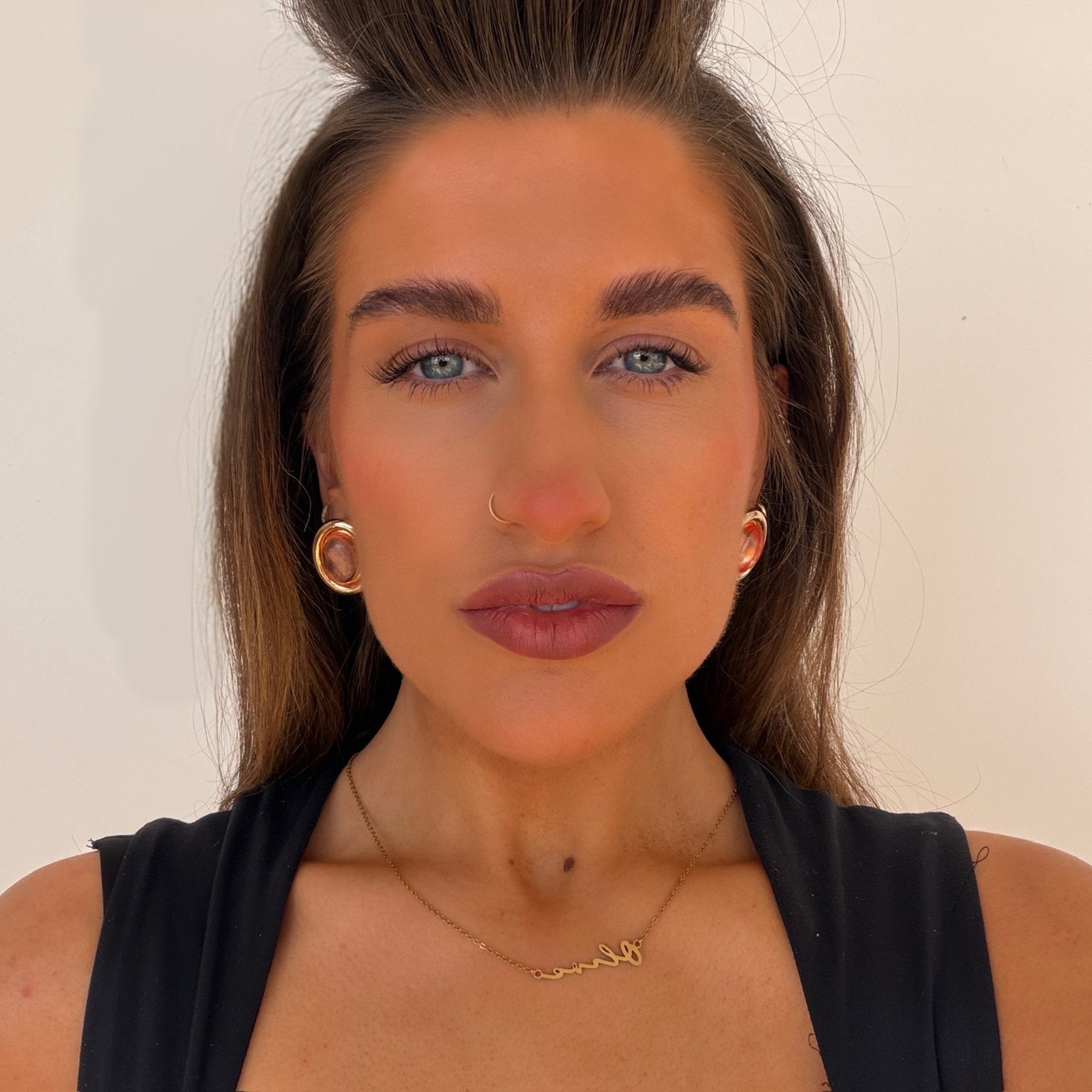 Woman with styled hair and makeup against a plain background