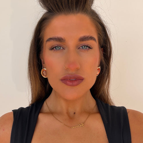 Woman with styled hair and makeup against a plain background
