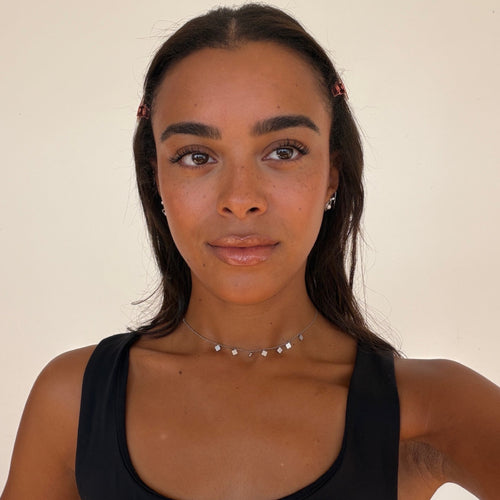 Woman wearing a black tank top against a plain background