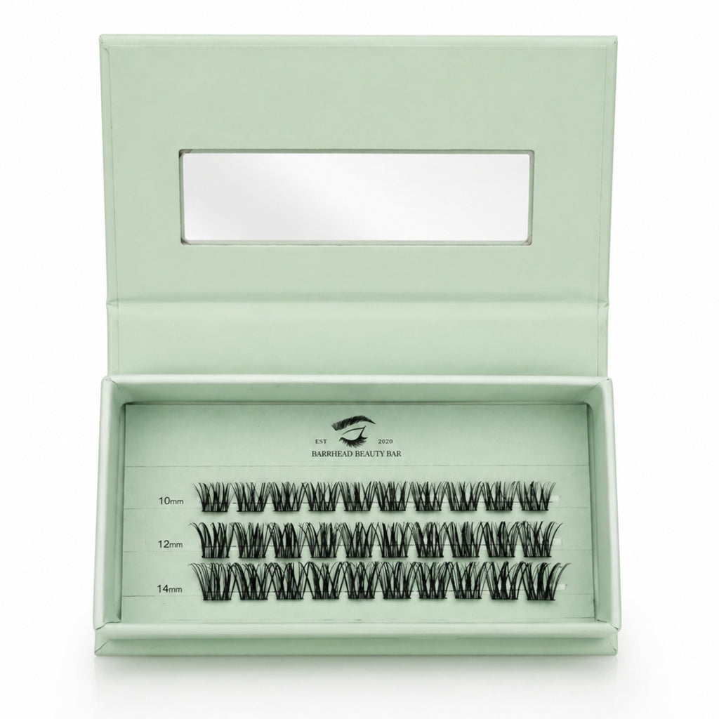 Set of false eyelashes in a green box with a clear lid on a white background